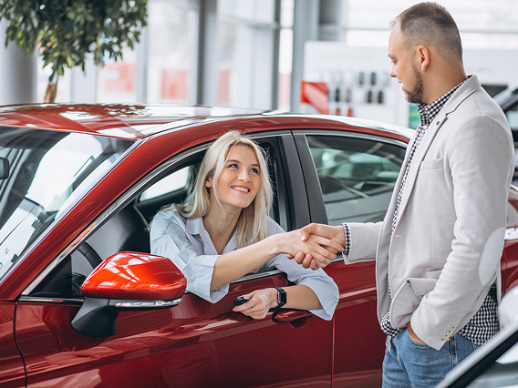 Man by his vehicle speaking with a loan specialist