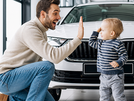 Family celebrating their new car with a loan specialist